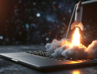 Rakete schießt aus der Laptop-Tastatur, Flamme und Rauch; Funken, Laptop auf dunklem Tisch, Hintergrund unscharf.