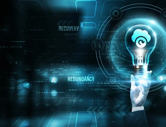 Futuristisches, blaues Tech-Interface; eine Hand berührt eine leuchtende Glühbirne in einer kreisförmigen Anzeige.
