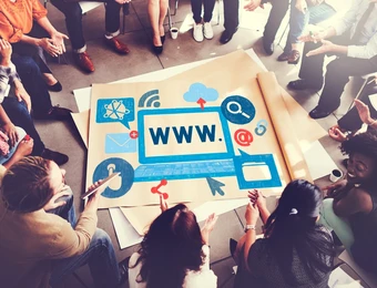Gruppe von Menschen sitzt im Kreis um eine große Skizze eines Laptops mit WWW und Web-Symbolen.