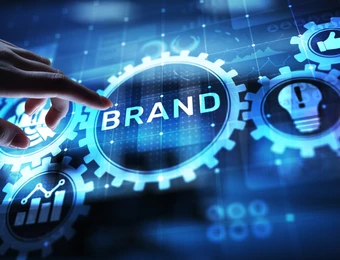 Eine Hand berührt eine leuchtende Scheibe mit dem Wort BRAND, umgeben von blauen Zahnrädern und Symbolen.