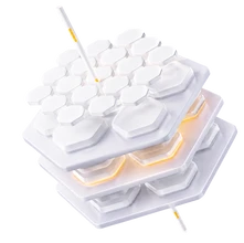 Weiße modulare Tastatur mit hexagonalen Tasten in drei Schichten; orange Leuchtelemente, Kabel sichtbar.