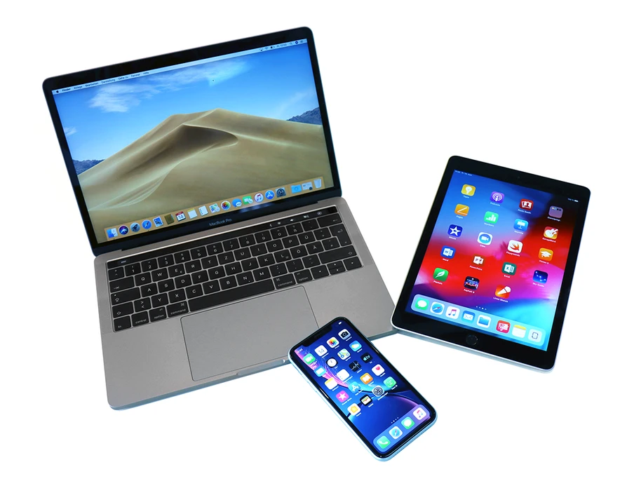 Ein Laptop, Tablet und Smartphone auf weißem Hintergrund; Laptop-Display zeigt Sanddünen.