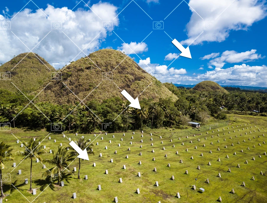 Grünes Feld mit kegelförmigen Hügeln, Palmen am Rand; blauer Himmel mit Wolken; weiße Marker in regelmäßigem Muster.