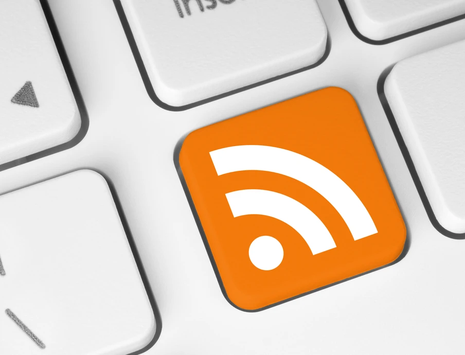 Orangefarbene RSS-Feed-Symbol-Taste auf einer weißen Tastatur.