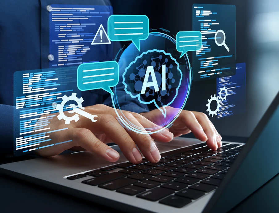 Hände tippen auf Laptop-Tastatur; virtuelle blaue AI-Symbole, Chatblasen und Codeschirme schweben über dem Bildschirm.
