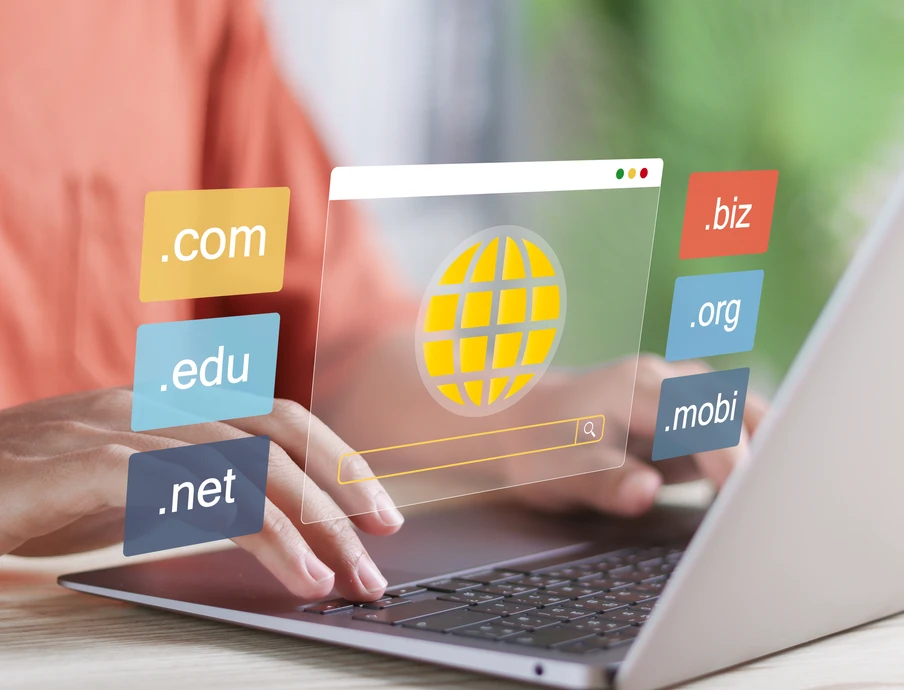 Person tippt auf Laptop; transparentes Fenster zeigt gelben Globus und Domain-Icons (.com, .net, .org, .edu, .biz, .mobi).