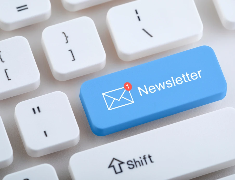 Blaue Tastenkappe mit Newsletter und Briefumschlags-Symbol auf weißer Tastatur.