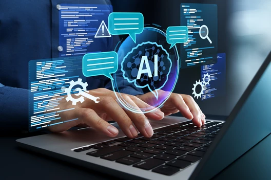 Hände tippen auf Laptop-Tastatur; virtuelle blaue AI-Symbole, Chatblasen und Codeschirme schweben über dem Bildschirm.