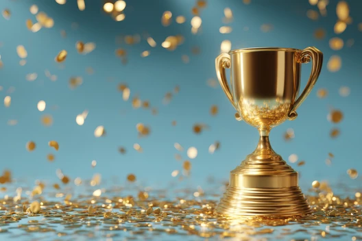 Goldener Pokal mit zwei Henkeln auf einem gerippten Sockel, Konfetti fällt vor blauem Hintergrund.